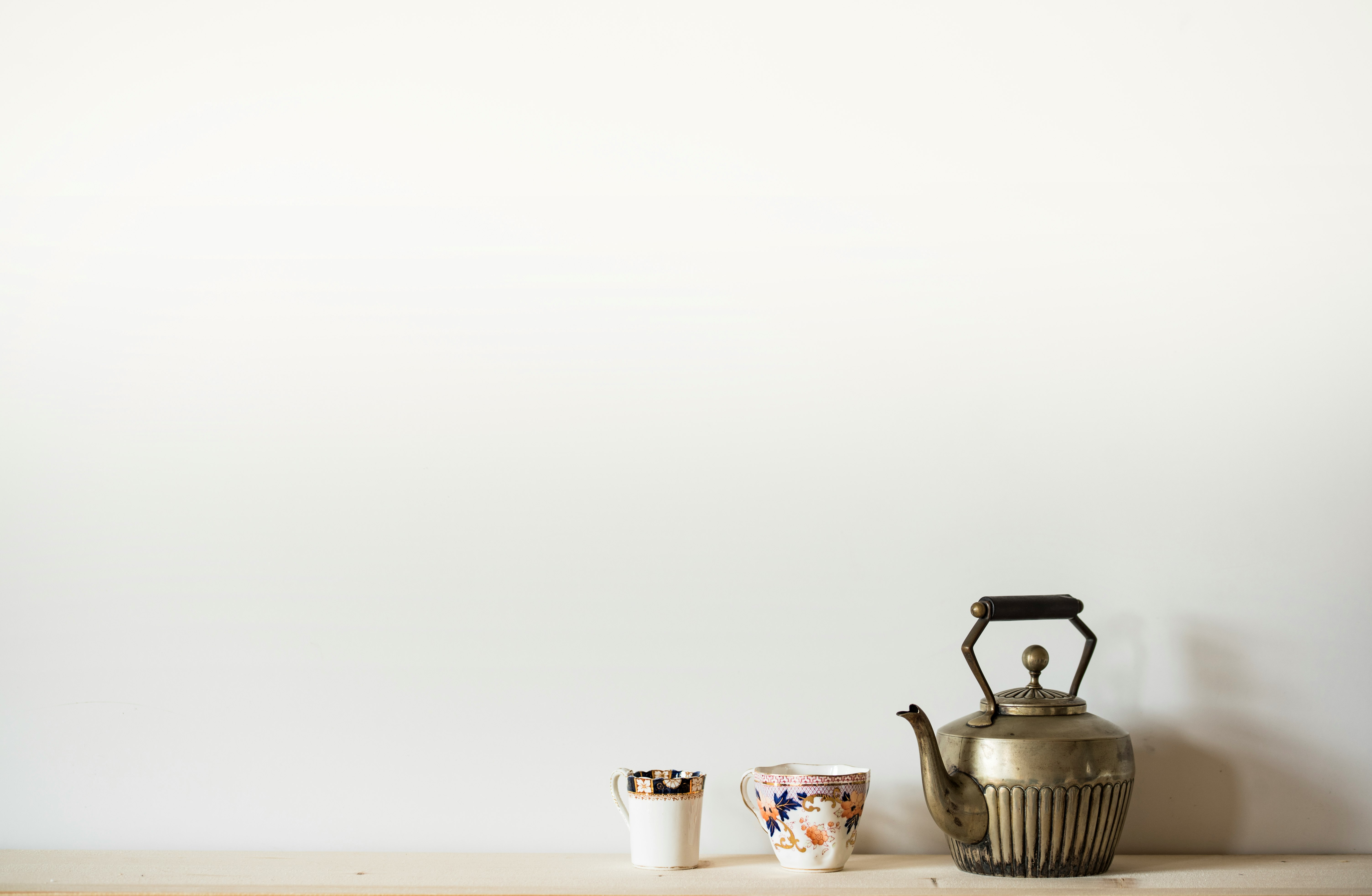 silver kettle beside two mugs